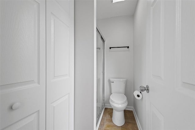 bathroom with tile patterned floors, toilet, and an enclosed shower