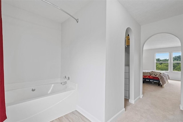 bathroom featuring a tub and a textured ceiling