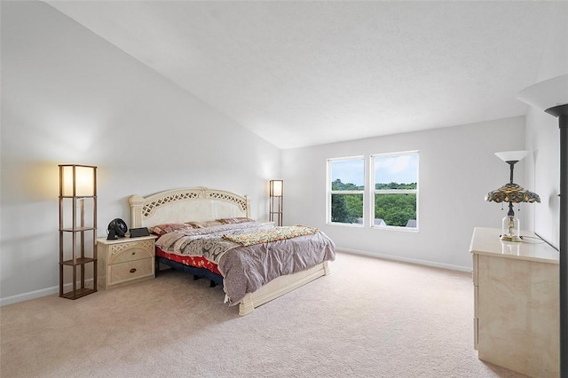 carpeted bedroom with high vaulted ceiling