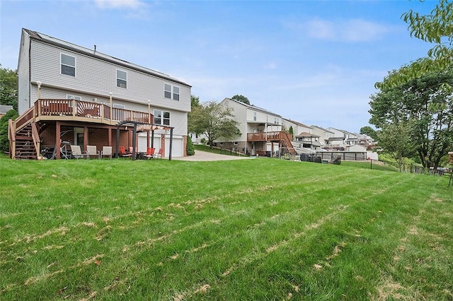 back of house featuring a lawn, a garage, and a wooden deck