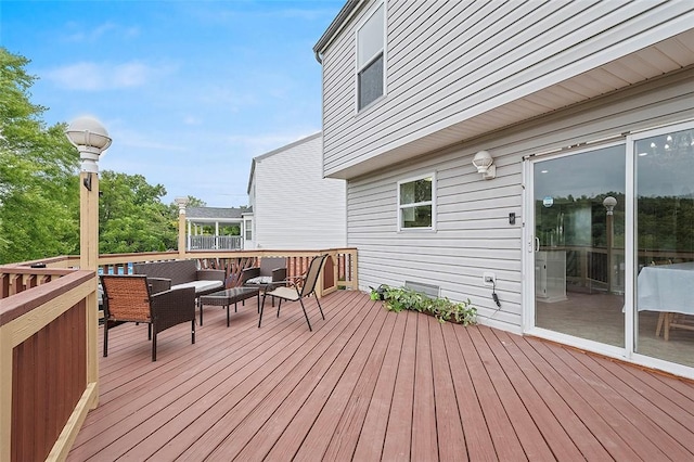 wooden terrace with an outdoor living space