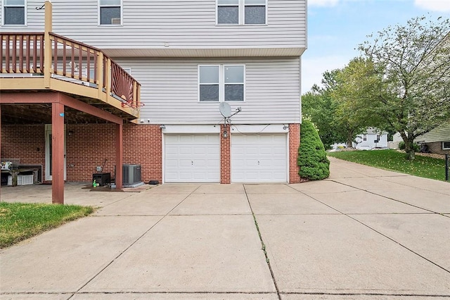 view of home's exterior with a garage, a wooden deck, and central AC