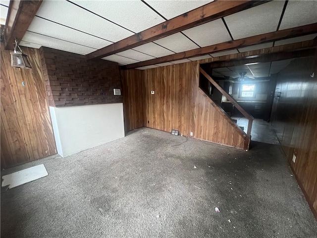 basement with carpet flooring and wood walls