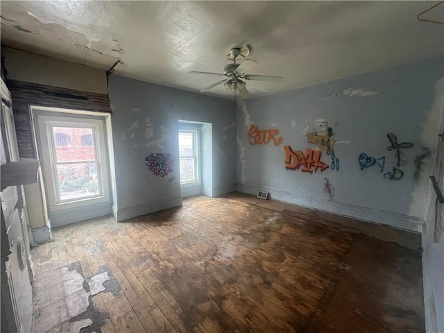 spare room with hardwood / wood-style flooring, a wealth of natural light, and ceiling fan