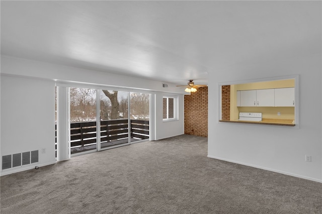 unfurnished living room featuring a wealth of natural light and carpet