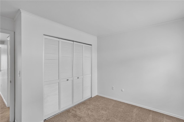 unfurnished bedroom featuring light colored carpet, a closet, and ornamental molding