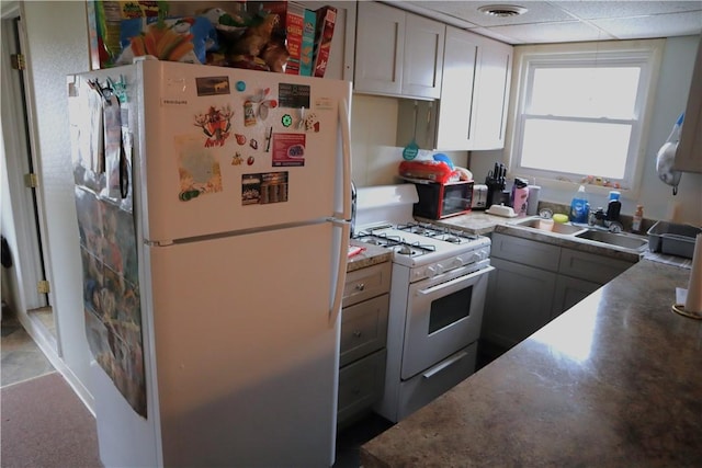 kitchen with gray cabinets, a paneled ceiling, sink, and white appliances