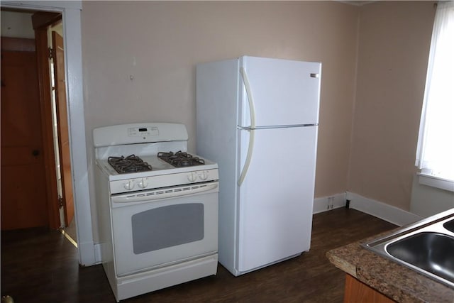 kitchen with sink, dark wood-type flooring, and white appliances