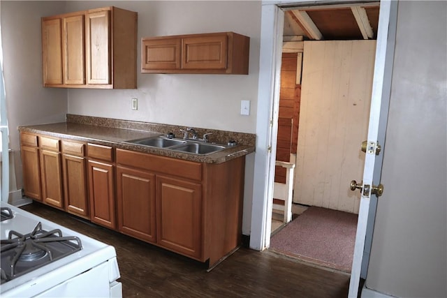 kitchen with white gas range oven, dark hardwood / wood-style floors, and sink