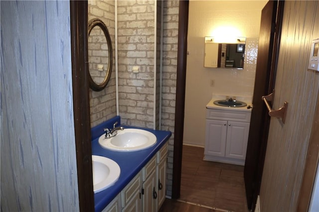 bathroom with vanity and brick wall