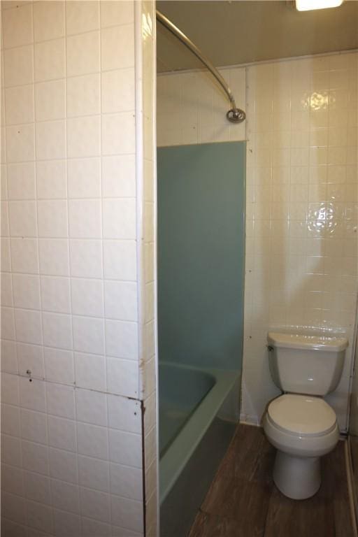 bathroom featuring toilet and tile walls