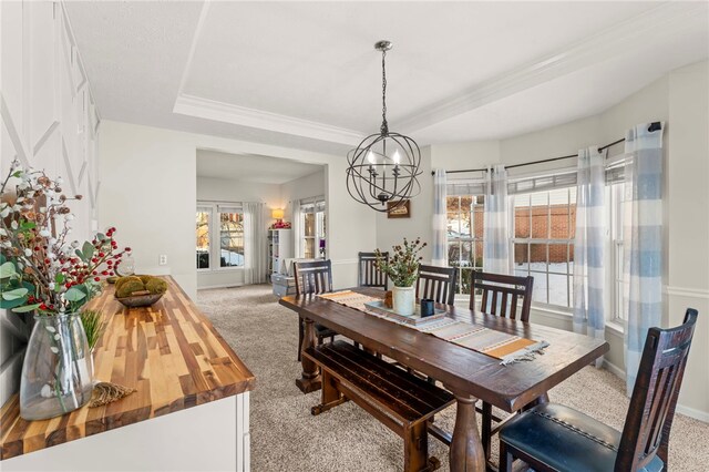 carpeted dining room featuring a tray ceiling and a notable chandelier