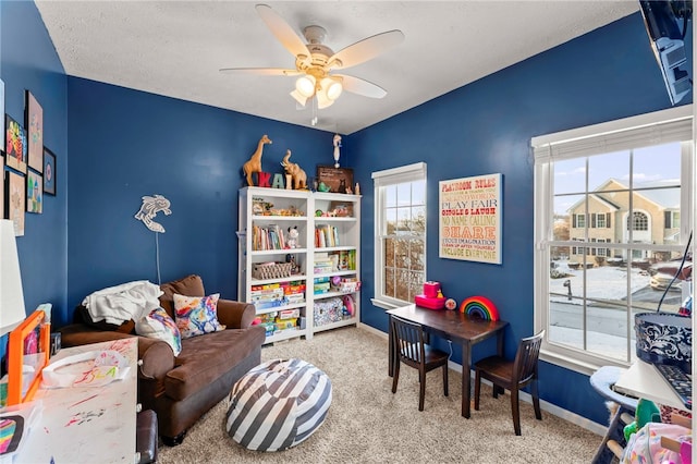 game room with carpet flooring, ceiling fan, and a textured ceiling