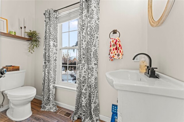 bathroom featuring hardwood / wood-style floors and toilet