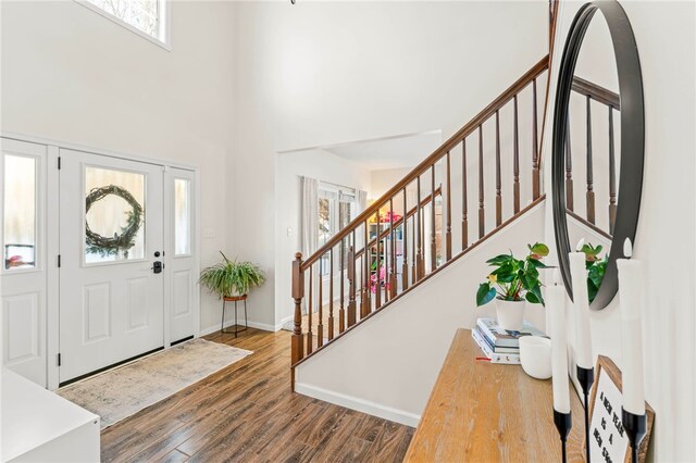 entrance foyer featuring hardwood / wood-style floors and a towering ceiling