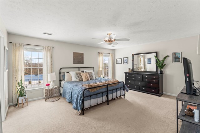 carpeted bedroom with a textured ceiling and ceiling fan