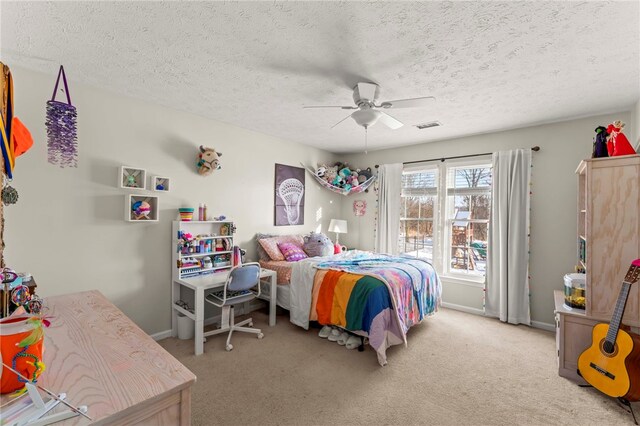 carpeted bedroom featuring ceiling fan and a textured ceiling