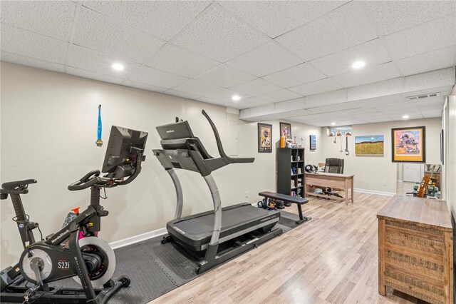 exercise area featuring hardwood / wood-style floors and a drop ceiling