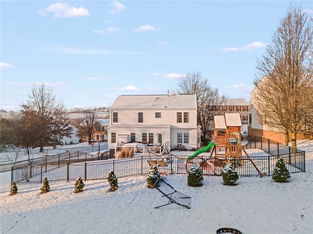 snow covered house featuring a playground