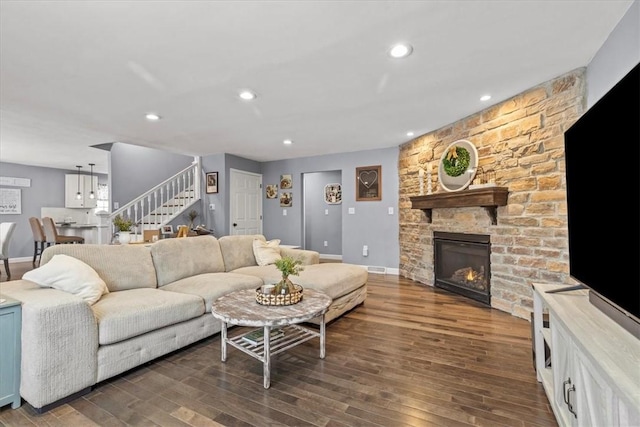 living room featuring dark hardwood / wood-style flooring and a stone fireplace