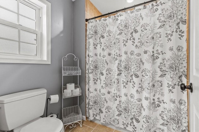 bathroom featuring walk in shower, tile patterned flooring, and toilet