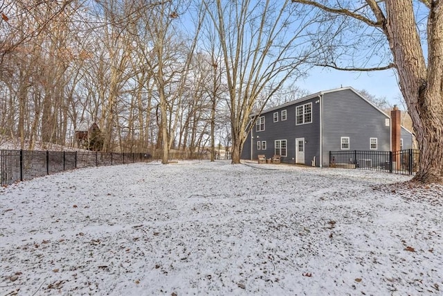 view of snow covered back of property