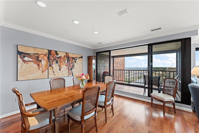 dining room featuring hardwood / wood-style flooring and crown molding