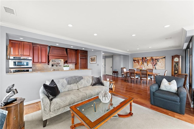 living room featuring light wood-type flooring and crown molding