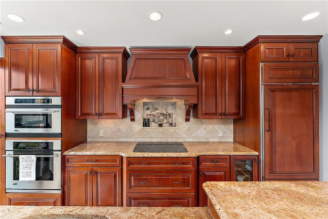 kitchen featuring double oven, backsplash, custom range hood, and black electric cooktop