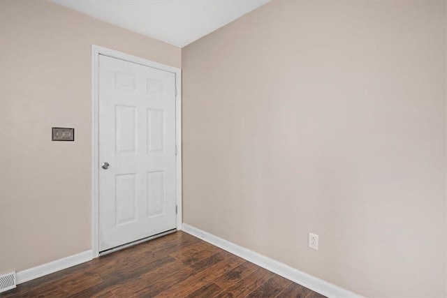 unfurnished room with dark wood-type flooring