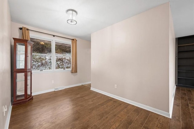 empty room with dark wood-type flooring