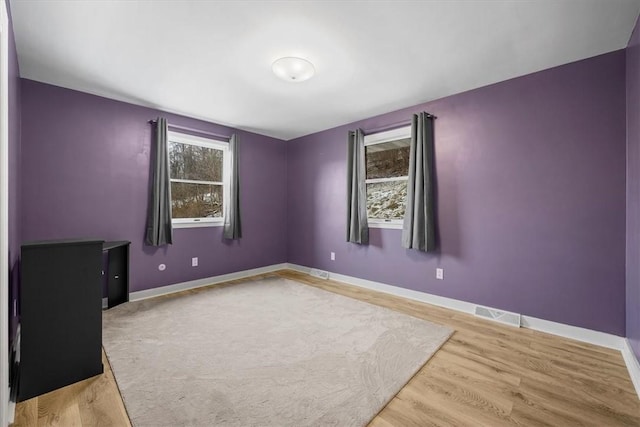 empty room featuring plenty of natural light and wood-type flooring