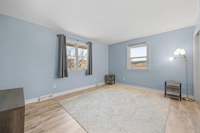 empty room with plenty of natural light and light wood-type flooring