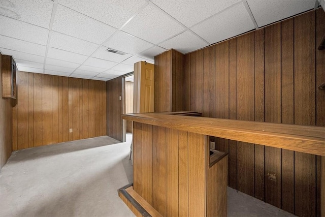 bar featuring a paneled ceiling, butcher block countertops, and wooden walls