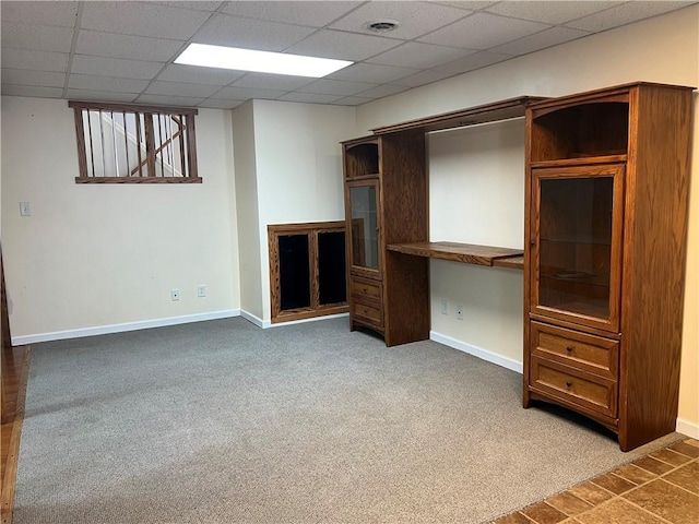 unfurnished living room featuring carpet flooring and a paneled ceiling