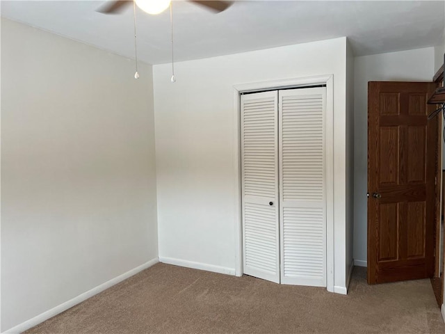 unfurnished bedroom featuring ceiling fan, a closet, and carpet floors