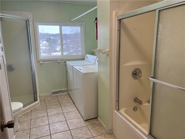 bathroom featuring shower / bath combination with glass door, tile patterned flooring, washer and dryer, and toilet