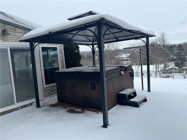 snow covered patio with a hot tub