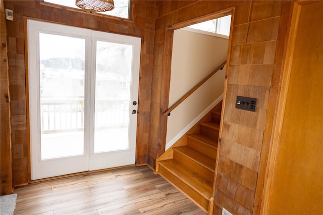 foyer entrance featuring plenty of natural light, stairs, and light wood-style floors