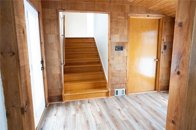 staircase featuring vaulted ceiling, wood finished floors, and visible vents