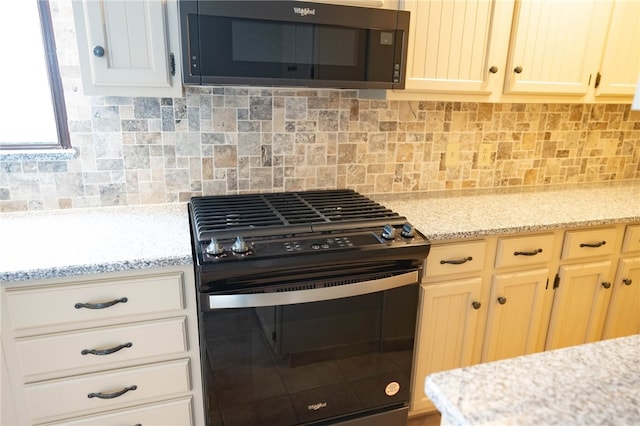 kitchen featuring black range with gas cooktop, decorative backsplash, and light stone countertops