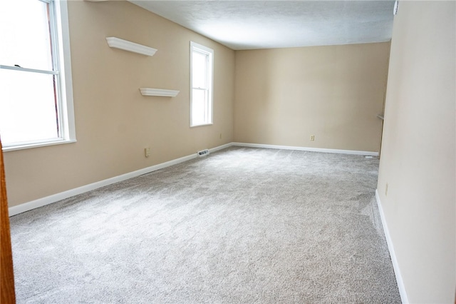 carpeted spare room featuring baseboards