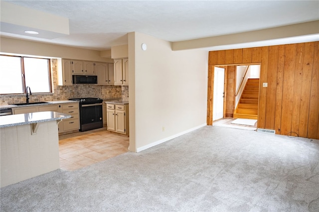 kitchen featuring visible vents, light carpet, black appliances, a sink, and tasteful backsplash