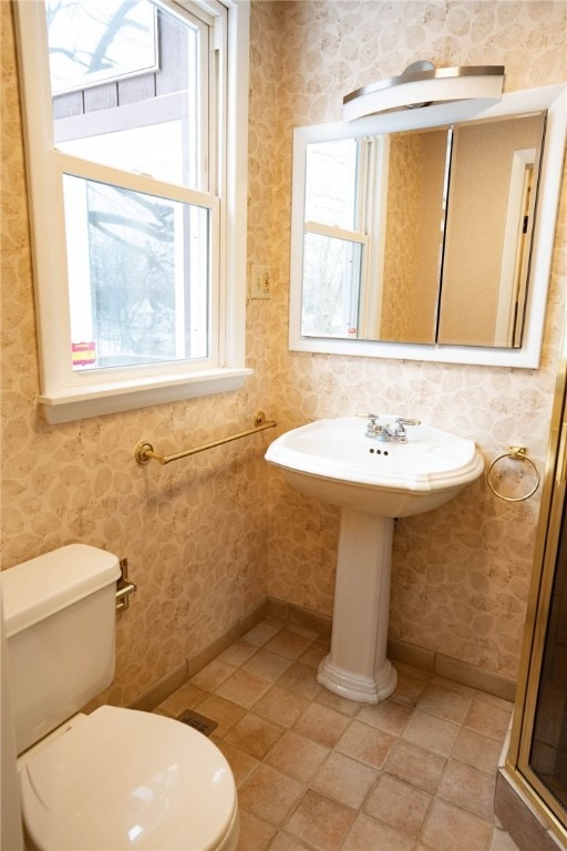 bathroom featuring wallpapered walls, toilet, and baseboards