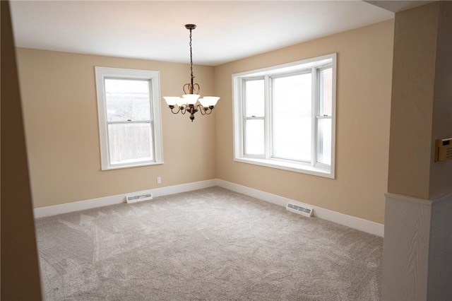 empty room featuring visible vents, a healthy amount of sunlight, and carpet