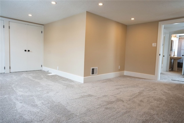 unfurnished room with recessed lighting, visible vents, and light colored carpet