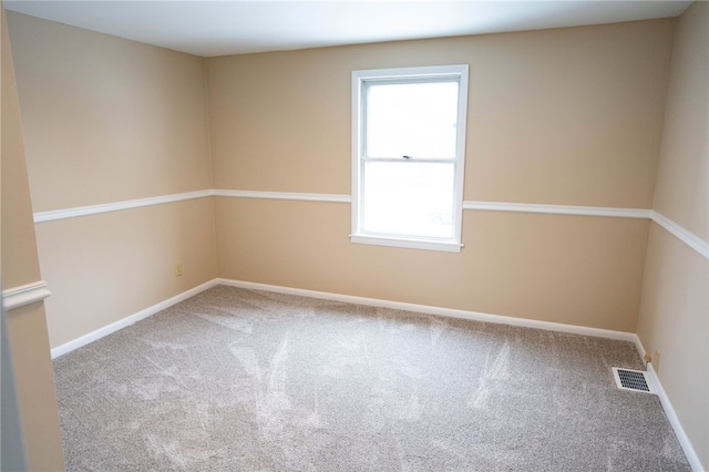 carpeted empty room featuring baseboards and visible vents