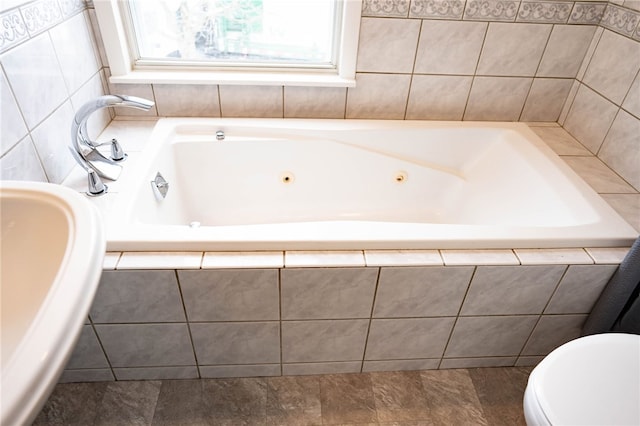 bathroom featuring toilet and a tub with jets