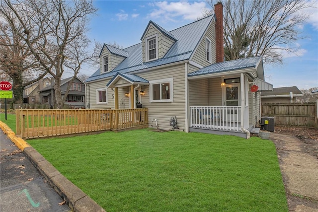 cape cod-style house with metal roof, a front lawn, a chimney, and fence