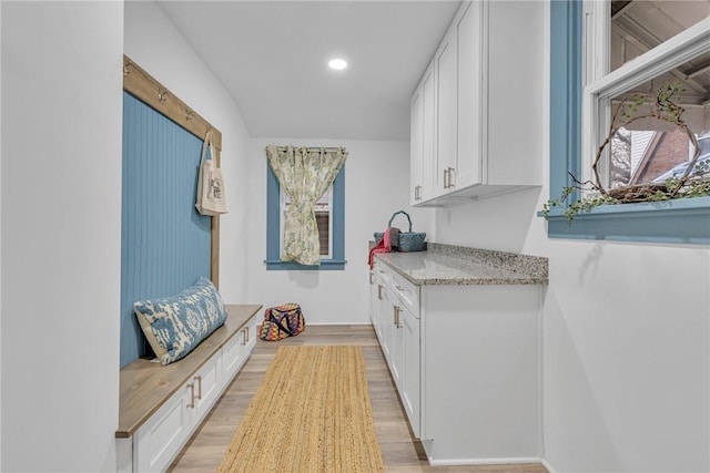 interior space featuring light wood-type flooring, white cabinetry, light stone countertops, and recessed lighting